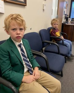 When the school called and told me my seven-year-old son had been in a fight, I thought I would arrive to find tears, apologies, and a frightened child. Instead, I stepped into the principal’s office and saw another boy with my son’s face, his scar, and his eyes. Then the boy’s mother walked in and destroyed my life with one sentence.I was folding laundry when the school’s number appeared on my phone.

“Ma’am, there’s been an incident with Noah,” the secretary said. “A physical altercation. Please come right away.”

I drove far faster than I should have.

My son was seven, and he was the kindest child I had ever known.

I could not picture him fighting anyone.

Noah had never so much as lifted a hand against another child.

—

My heels sounded too sharp against the floor as I hurried toward the principal’s office.

The door stood halfway open.

I pushed it open the rest of the way and froze.

For a second, my mind could not process what I was seeing.

Noah sat in a small wooden chair against the wall, his face blotchy from crying.

Beside him was another boy, and the sight of him stole the air from my lungs.

The same little upturned nose as Noah.

The same dark eyes.

The same gap between his front teeth.

He even had the same small scar above his left eyebrow!

The whole room seemed to shrink until all that existed were those two identical, impossible faces staring up at me.

I did not know it then, but I had just walked into a secret I was never meant to find.

“Ma’am.” Principal Hayes stood. “Please, sit down. We’re still waiting on the other parent.”

I lowered myself into the chair across from the boys.

I could not stop staring at the child who looked like he had borrowed my son’s face.

“Mom, I didn’t start it,” Noah whispered, his bottom lip trembling. “He has my compass. He said his dad gave it to him.”

“Your compass?” I murmured. “The one your dad gave you for your birthday?”

Noah nodded.

I turned toward the other boy.

He watched me with guarded, careful eyes.

“What’s your name, honey?”

“Lucas,” he said quietly.

Even his voice sounded almost like Noah’s.

“Lucas.” I tried to smile. “That’s a nice name. How old are you?”

“Seven.”

Seven… The same age as Noah.

How could two children look so unbelievably alike?

I pressed my palms flat against my knees so they would not shake.
I told myself coincidences existed.

I told myself there had to be some harmless explanation.

Then the office door clicked open behind me.

I turned toward the sound.

A woman stepped inside.

She looked to be in her mid-thirties, with dark hair pulled back.

The moment she saw me, she stopped cold.

Her jaw tightened, and her eyes widened.

She clearly knew who I was, and my presence had caught her completely off guard.

I looked at her more closely, and that was when recognition began to creep in.

I knew her from somewhere.

I searched through my memories.

She moved farther inside and turned slightly to close the door.

When she faced the principal again, I recognized her all at once.

She was a nurse.

She had brought me medication three days after Noah was born.

She had smiled at me and said, “You have a beautiful boy. Not every woman is given the gift of having a child.”

At the time, it had made me cry.

I looked at Lucas, then back at her.

Was she his mother?

The boy did not resemble her at all.

The principal cleared his throat. “Thank you both for coming. Now, let’s address why we’re here.”

Noah and Lucas both dropped their eyes immediately.

Principal Hayes sighed. “Apparently the disagreement started over these.”

He opened a drawer and placed a brass compass on the desk.

I recognized it instantly.

Mark had given that compass to Noah.

Principal Hayes gestured toward it. “Both boys claim this belongs to them.”

“My dad gave it to me,” Noah said.

Lucas frowned. “My dad gave me mine.”

I cleared my throat. “Excuse me, but there could be a simple way to tell who the compass belongs to.”

“Yes?” Principal Hayes nodded to me.

“Noah does have a compass exactly like that, but his has a small ‘M’ scratched on the back. It’s his father’s initial.”

Principal Hayes flipped the compass over.

“That won’t help,” the nurse cut in. “Lucas’s compass also has an ‘M’ scratched on the back.”

Principal Hayes lifted his eyebrows.

Another match…

Principal Hayes cleared his throat once more.
“In that case, I suggest you both check your children’s things to see which of them is missing their compass. With your permission, we’ll keep this until the rightful owner can be identified.”

I nodded.

The nurse nodded as well.

“The boys argued about the compass during lunch,” Hayes continued. “Things escalated. Neither child was seriously hurt, but we need to make sure this doesn’t happen again.”

Both boys nodded.

The principal’s expression softened. “Good. That’s settled.”

—

The woman, Elena, rushed out of the office the moment the meeting ended.

I caught up with her in the parking lot.

I stared at her, unsure how to begin.

Then she released a tired breath.

“Susan, I hoped we would NEVER meet,” she said quietly. “I really did.”

“How do you know my name?” I asked.

“I’ve known your name for seven years.”

“Start talking. Right now. Why does Lucas look exactly like Noah?”

She inhaled, and I could see her forcing herself to be brave.

She sat down on a bench facing the parking lot.

“It’s time you know what your husband really did.”

“What Mark did?” A cold fear crawled down my spine.

She nodded. “I worked at St. Mary’s seven years ago.”

“I know. I remember you.”

“Something happened at that hospital that you were never supposed to know.”

My stomach seemed to drop. “What does that mean?”

“Two boys were born a few months apart.”

“So?”

“There were concerns about birth records.”

For the first time since I had walked into the school, a terrifying thought began forming.

What if one of those boys belonged to someone else?

What if my son was not really mine?

I stared at her. “What are you saying?”

Elena looked away, then met my eyes again.

And in that instant, I understood.

The fear on her face was not the fear of someone revealing a secret.

It was guilt.

“Answer me.”

She slowly reached into her bag and took out her phone.

“I don’t want to do this here,” she said. “I never wanted to do this at all. I begged Mark to tell you. For seven years I begged him.”

“You know Mark?” I leaned away from her. “Are you telling me what I think you’re telling me?”

She nodded, and something inside my heart split open.

“Why now?”

“Because our boys go to the same school now. Because Lucas came home last week and said he met a boy who looked just like him.”

“Why are you doing this to me?” I asked, and my voice cracked.

Elena’s eyes softened.

“I’m not doing this TO you,” she said. “I’m doing this FOR my son. He deserves to stop being a secret.”

“And what about my son?”

“Your son deserves a mother who knows the truth.”

I struggled to draw air into my lungs.
“Show me,” I whispered. “You must have evidence.”

“The hospital records show his name as the father on both birth certificates,” she said. “There’s also this.”

She unlocked her phone, tapped the screen, and held it out.

And as my fingers closed around it, I knew I was about to watch the last seven years of my life be rewritten in front of me.

The first picture showed Mark in a hospital gown, holding a newborn.

The next showed Lucas on a tricycle, with Mark behind him, hands on the handlebars.

The next was Lucas blowing out birthday candles.

Mark stood beside him, leaning close, wearing the same proud smile I had captured so many times at our own kitchen table.

I pressed my hand over my mouth.

Everything fell apart at once.

“That’s why they look so much alike. The boys are half-brothers. Mark is their father, and he…” I stared at her as tears filled my eyes. “He’s been having an affair with you for years.”

“Yes.” Elena put her phone back into her purse. “But there’s more you need to know.”

She took out an envelope.

“What’s that?”

“Just look.”

She held it toward me.

I pulled out the papers and began flipping through them.

I thought I had already heard the worst news I would ever hear.

The envelope proved I was wrong.

Bank statements.

Account numbers I recognized, and one I did not.

“What is this?”

“He bought us a house. Two streets behind the school. He paid cash from your joint account in increments small enough that you would not notice if you were not looking closely.”

“He told me I was being paranoid when I asked about the savings last spring.”

“He told me you had agreed to a separation,” Elena said. “He told me you were the one delaying the divorce.”

A sound escaped me that almost resembled laughter. “We never discussed a divorce.”

Her face went completely still.

For a moment, we simply stared at each other.

Two women trapped in the same lie, each hearing a different version from opposite sides.

And I knew one thing with absolute certainty: Mark had been getting away with this for much too long.

I pulled out my phone.

Mark answered on the second ring.

“Hey, babe, I’m in a meeting, can I—”

“Come to Noah’s school. Right now.”

“Is he okay? What happened?”

“Come to the school, Mark.”

There was a pause.

“I’m twenty minutes out—”

“Make it ten.”

I ended the call.

Elena was watching me.

“Well, are you staying to confront him with me, or are you leaving?”

Elena breathed out and looked across the parking lot.

“I’ll stay,” she said softly. “This has gone on for long enough.”

Ten minutes later, a black SUV swung into the lot.

Mark got out.

His tie was crooked.

Sweat shone on his face.

The second he saw Elena sitting next to me, he froze.

For the first time in seven years, he looked frightened.

“Sweetheart,” he said quickly. “Whatever she told you, it’s a lie.”

I laughed.

Not because any of it was funny.

Because there was nothing else left for me to do.
“Really? Which part, Mark? The one where our son has a half-brother, or the one where you took money from our joint account to buy your second family a house?”

“All of it!” Mark dragged his fingers through his hair. “Are you serious right now? This woman tells you—”

“Stop right there with your lies.” I pointed at him. “I saw Lucas. He’s practically Noah’s twin. And I saw the bank statements that prove you’ve been moving money around.

Mark glanced at Elena.

Then at the envelope in my hand.

His face went pale.

“She’s obsessed with me,” he said. “I’ve told you that before.”

Elena stared at him.

“No,” she said quietly. “You told me your wife was obsessed with keeping you trapped.”

He turned toward her.

“Elena—”

“You told me you were getting separated.”

His mouth opened.

No words came.

“You told me she refused to sign divorce papers,” Elena continued.

I lifted my left hand.

My wedding ring was still on it.

“I didn’t even know there was supposed to be a divorce. When were you planning to tell me, Mark?”

Mark looked from her to me.

For the first time, he had nowhere left to hide.

“You lied to both of us,” I said.

“I was trying to protect everyone.”

“Protect?” Elena stood. “Lucas spent seven years waiting for you to show up at school events because you said people couldn’t know he existed.”

His shoulders dropped.

I pulled the bank statements from the envelope.

“And this?”

Mark said nothing.

“The house. The money. Noah’s college fund.”

“I was going to pay it back.”

Somehow, that made it worse.

A heavy silence settled over the parking lot.

Then Elena shook her head.

“You know what’s pathetic?” she said. “For years, I thought I was the other woman.”

I looked at her.

“So did I.”

Mark flinched.

Good.

He should have.

I slid my wedding ring off and pressed it into his palm.

The small gesture seemed to age him by a decade.
“We’re done.”

“Please,” he whispered.

“No.”

His eyes filled with panic.

Not grief.

Not regret.

Panic.

Because for the first time, he understood what he had lost.

Not one family.

Both.

Elena stood beside me.

Neither of us touched him.

Neither of us shouted.

We did not need to.

The truth had already caused all the damage.

Mark stood alone in the center of the parking lot while the two women he had lied to walked away in opposite directions.

And for the first time in seven years, there was no one left waiting for him at home.